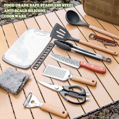 Verschiedene Küchengeräte auf Holztisch im Freien.